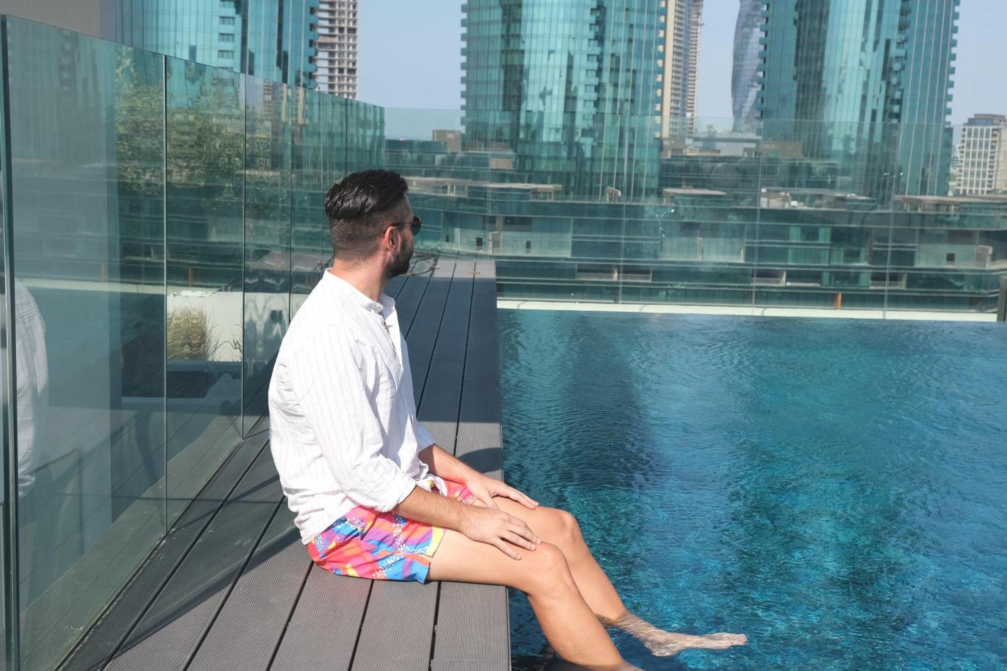 Hotel Charthouse Bahrain Manama Exterior foto A man sitting on the edge of a pool
