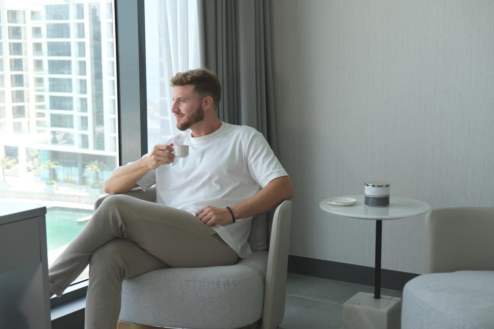 Hotel Charthouse Bahrain Manama Exterior foto A man drinking coffee